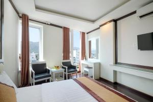 um quarto de hotel com uma cama e duas cadeiras e uma janela em Minh Tuyết Luxury Hotel managed by HT em Nha Trang