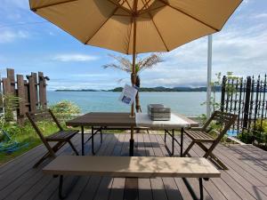 a table and two chairs and an umbrella on a deck at Amakusa VIVID - Vacation STAY 99413v in Kami Amakusa
