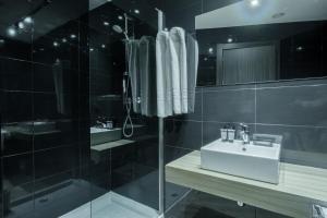 a bathroom with a sink and a glass shower at Apartamentos Capua in Gijón