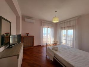 a bedroom with a large bed and a large window at Appartamenti Orchidea in Tropea