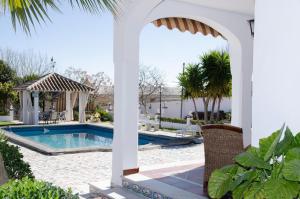 a white pavilion with a pool and a gazebo at Villa Vacacional Los Naranjos in Montemayor