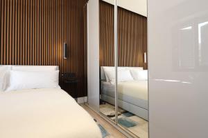 a bedroom with two beds and a mirror at Renovated & fully equipped-Luxurious-2Room Fontana Suite, it just doesn't get any better! in Olbia