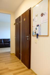 a hallway with two wooden doors in a room at Klaipeda Hostel in Klaipėda