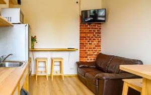 a living room with a couch and a kitchen at Klaipeda Hostel in Klaipėda