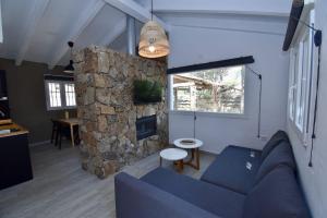 salon z niebieską kanapą i kamienną ścianą w obiekcie Casa Palmito 2 w mieście Chiclana de la Frontera