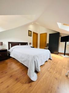 - une chambre avec un grand lit blanc et du parquet dans l'établissement Casa do Riacho - Douro, à Armamar