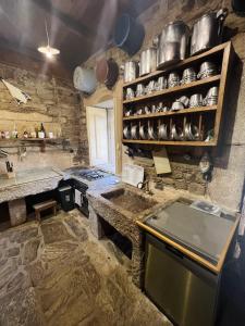 a kitchen with a sink and a counter with pots and pans at Casa do Riacho - Douro in Armamar