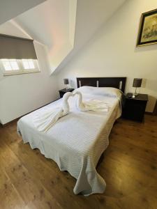 a bedroom with a large bed with white sheets at Casa do Riacho - Douro in Armamar