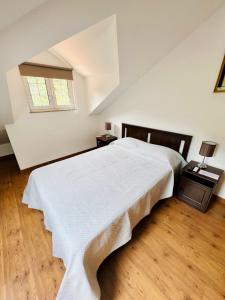 Un dormitorio con una gran cama blanca y una ventana en Casa do Riacho - Douro, en Armamar