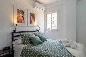- une chambre blanche avec un lit et des oreillers verts dans l'établissement Home Corinto Beach terraza y piscina - Benalmadena Malaga, à Benalmádena 28 autres photos