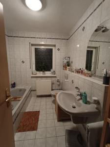 a bathroom with a sink and a tub and a toilet at Casa Montana in Scheiden