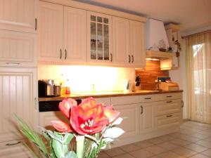 特拉森海德Ferienwohnung Strandidyll 2的花瓶里放着红花的厨房