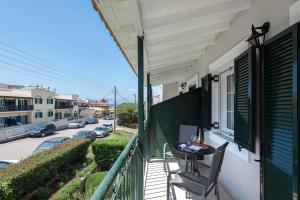 a balcony with a table and a view of a street at Ariti Apartments in Kassiopi