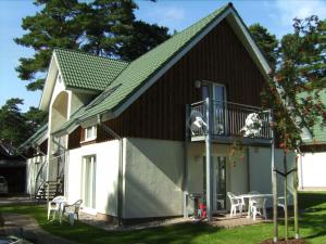 特拉森海德Ferienwohnung Strandidyll 2的带阳台和桌子的小房子