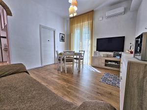 a living room with a table and a television at La Ca' Bianca Affittaly Rooms in Castenaso