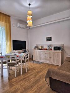a living room with a dining table and a tv at La Ca' Bianca Affittaly Apartments in Castenaso
