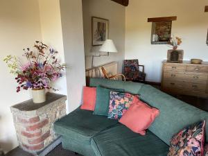 a living room with a green couch with colorful pillows at Phlomis in York