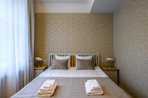 sypialnia z łóżkiem z dwoma ręcznikami w obiekcie Roze Kūrmājas Residence w mieście Lipawa
