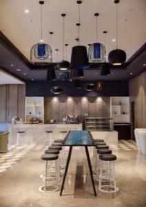 a large kitchen with a table and stools at AASHIYANA HOMESTEAD DLF My Pad in Lucknow