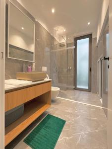 een badkamer met een wastafel, een toilet en een douche bij Vesper Suites in Dhërmi