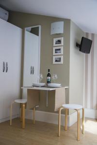 ベネヴェントにあるPiazza Roma Roomsのテーブル(椅子2脚付)とワイン1本