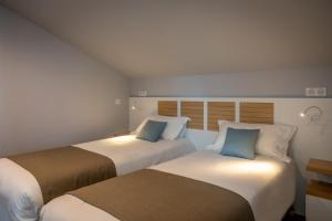 two beds sitting next to each other in a room at Hotel Atlantique in Le Palais