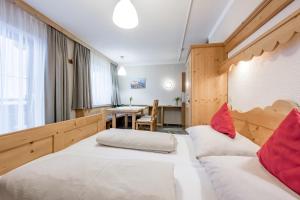 a hotel room with two beds and a table at Landhaus Edelweiss in Sankt Leonhard im Pitztal