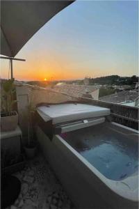 uma banheira com um pôr-do-sol ao fundo em Relax & Jacuzzi proche cité de Carcassonne em Pennautier