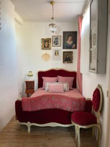 um quarto com uma cama rosa e um edredão vermelho em Relax & Jacuzzi proche cité de Carcassonne em Pennautier