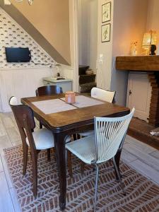 uma mesa de madeira e cadeiras numa sala de estar em Relax & Jacuzzi proche cité de Carcassonne em Pennautier