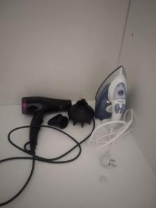 a black cat sitting next to a charger and a cord at Armenistis apartment in Armenistis