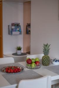 a table with a bowl of fruit and a pineapple at Araucarias apartment in Kotka
