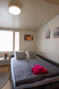 a bedroom with a large bed with pink objects on it at Araucarias apartment in Kotka