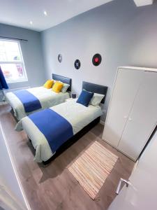 ロンドンにあるStylish 1 Bedroom Flat in wood Greenの青い壁のベッドルーム1室(ベッド2台付)