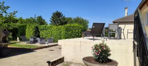 une terrasse avec une chaise et une plante en pot dans l'établissement Maison de village avec exterieur, à Oysonville