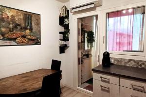 eine Küche mit einem Tisch und einem Gemälde an der Wand in der Unterkunft Appartement agréable pour 6 in Biguglia