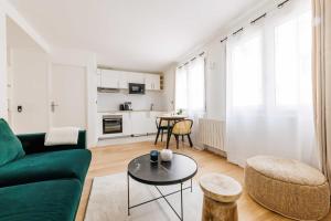 ein Wohnzimmer mit einem grünen Sofa und einem Tisch in der Unterkunft Charming Studio - 2P- La DéfensePuteaux in Puteaux