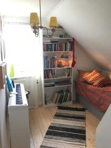 1 dormitorio con 1 cama y estantería con libros en Bo nära strand och city., en Västra Frölunda