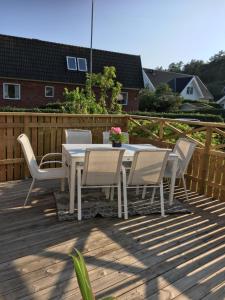 een witte tafel en stoelen op een houten terras bij Bo nära strand och city. in Västra Frölunda