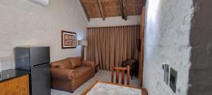 sala de estar con sofá y nevera en Bains Lodge, en Bloemfontein