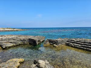 a group of rocks in the water near the ocean at Casa Camerini by MONHOLIDAY in Villanova di Ostuni