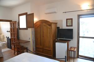 プルサーノにあるB&B Villa Dongiovanniのベッド、テレビ、ドアが備わる客室です。