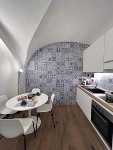 uma cozinha com uma mesa branca e cadeiras brancas em Vico37 Apartment em Acireale