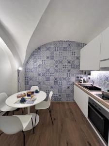 a kitchen with a white table and white chairs at Vico37 Apartment in Acireale