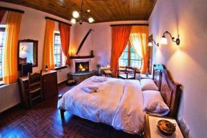 sypialnia z dużym łóżkiem i kominkiem w obiekcie Heliodora w mieście Kissos