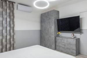 a bedroom with a bed and a flat screen tv at PETIT casa vacanze in Loreto