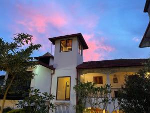 a white house with a clock tower on top of it at Elegant Hotel in Kandy