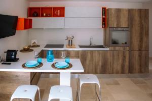 a kitchen with a white table and white stools at Il TrullOzio in Castellana Grotte