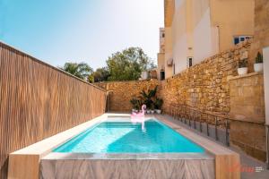 a swimming pool with a chair in the middle of a building at Spinola Stays in St. Julianʼs