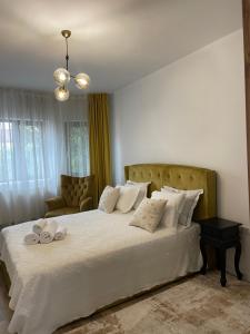 a bedroom with a large white bed with towels on it at Casa Din Targ in Horezu